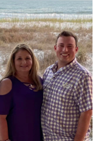 A person and person posing for a picture on a beach
Description automatically generated with medium confidence