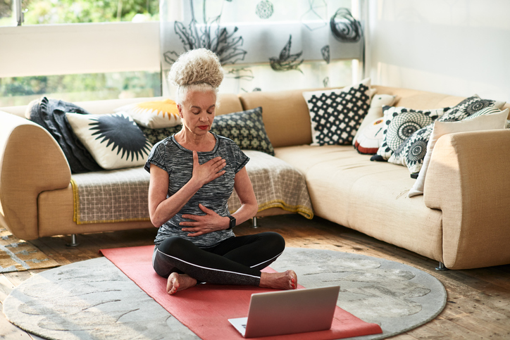 Older woman meditating on the floor