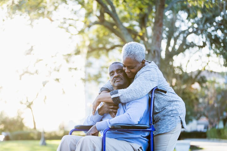 Woman hugging a man in a wheelchair