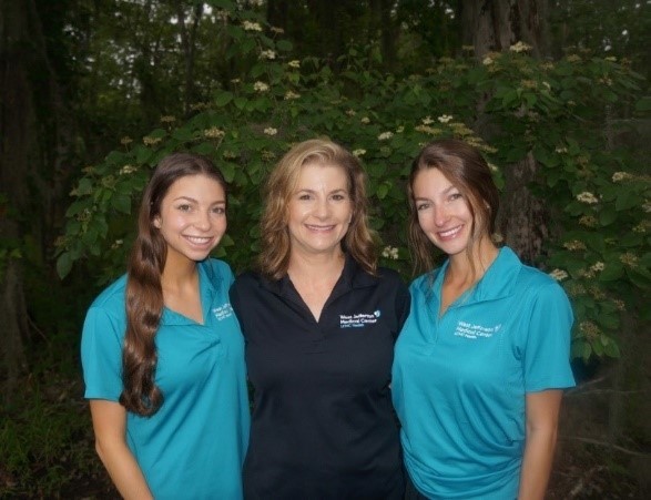 A group of women standing in front of a bush

Description automatically generated with low confidence