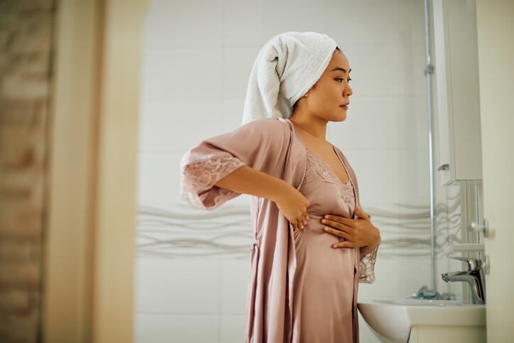 Women doing a breast exam in the mirror