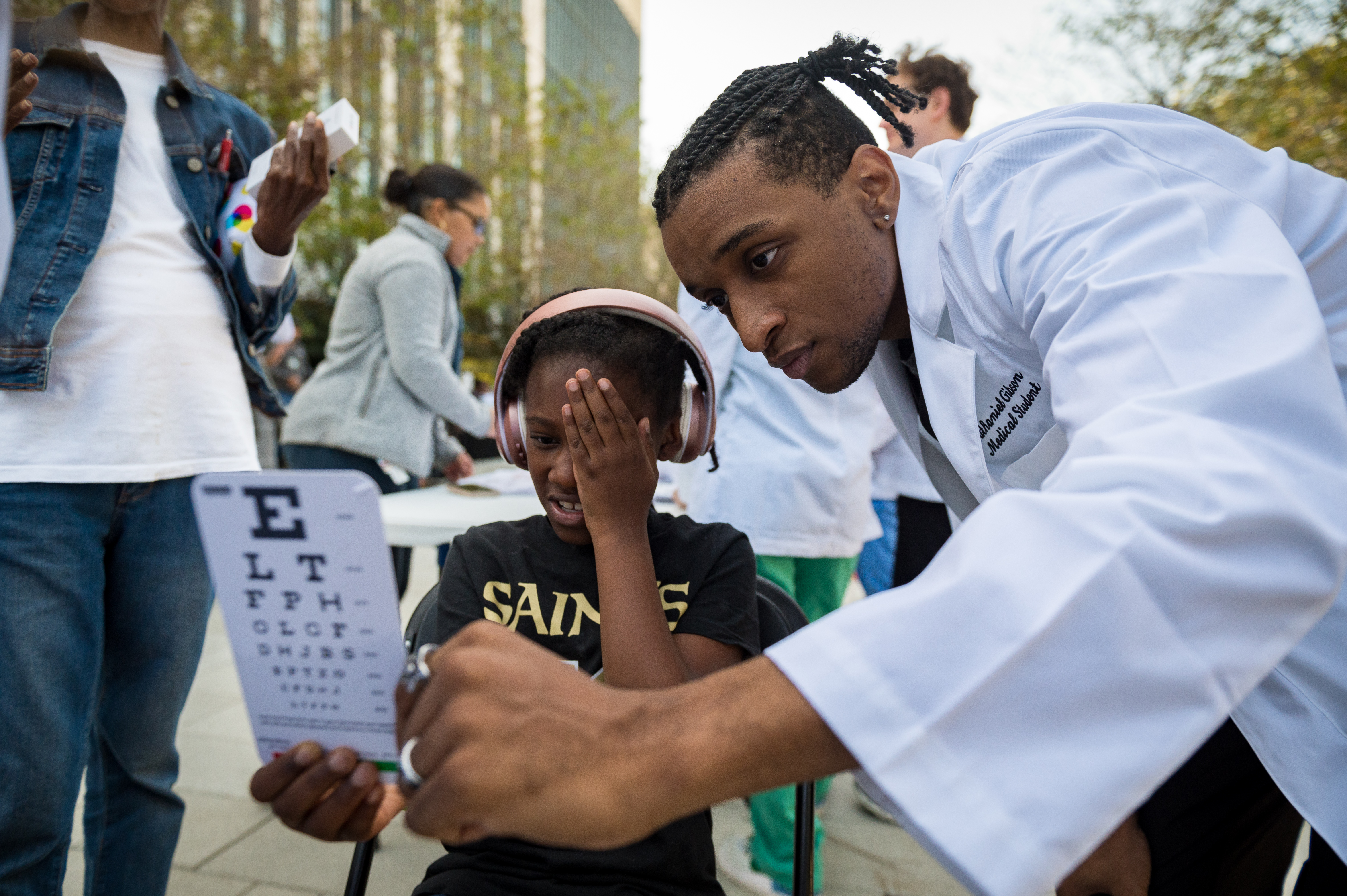 A UMC resident physician performing an eye exam at a community screening