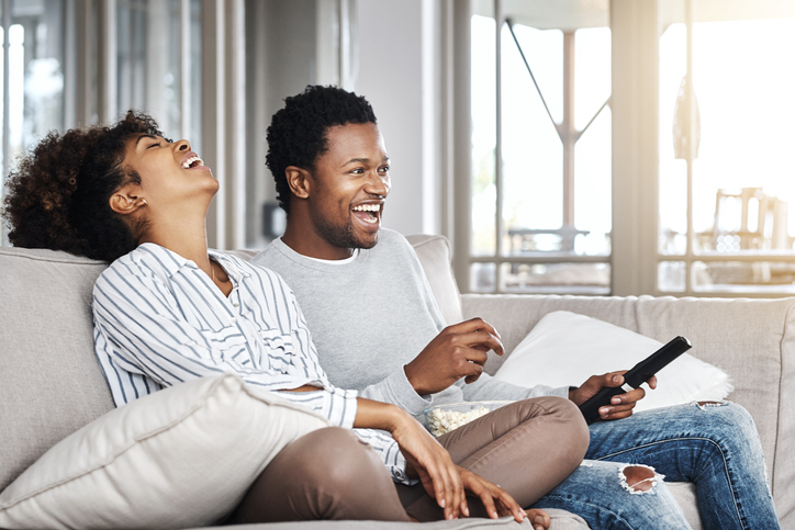 Black couple on couch eating popcorn