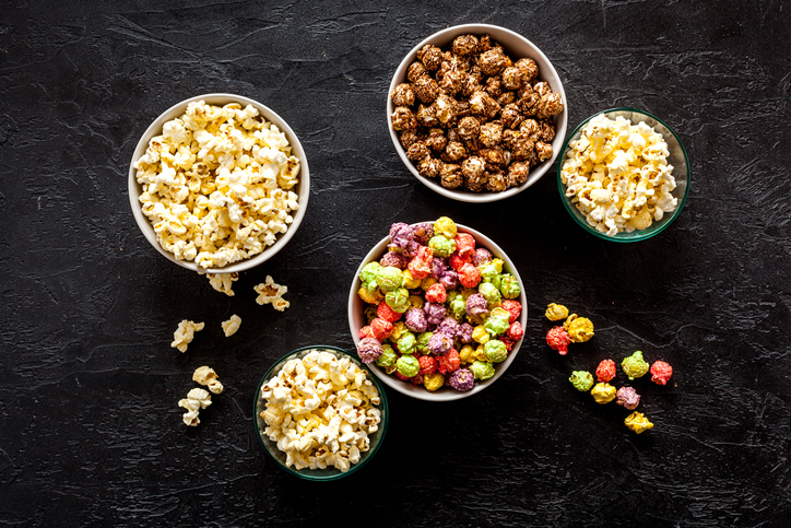 Five bowls of different flavored popcorn