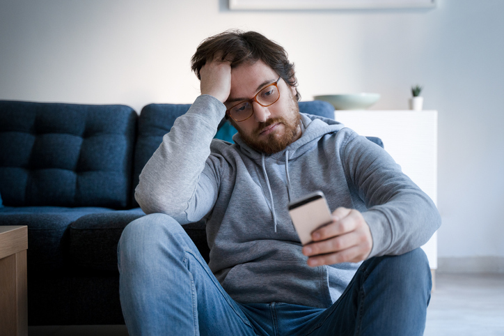 stressed man looking at his phone