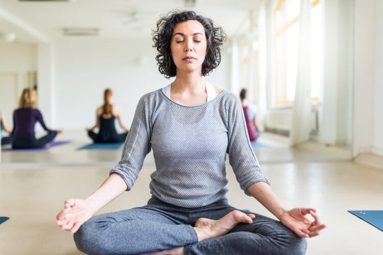 Woman meditating in yoga class