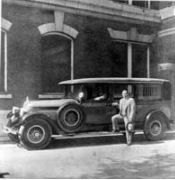 Gentleman standing in front of an ambulance in 1929