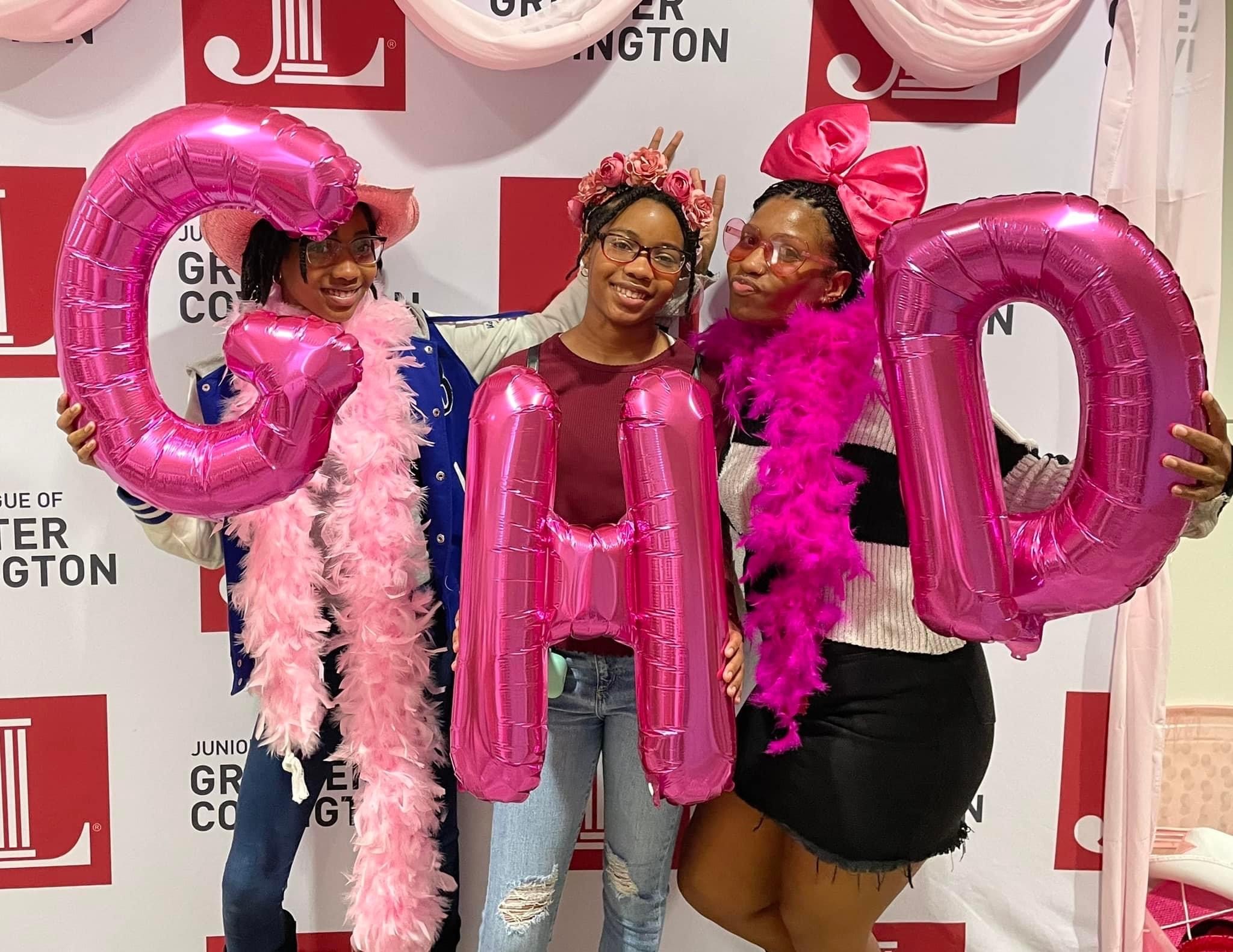 A photo of three girls holding balloons