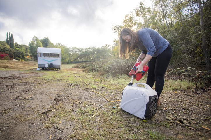 Woman pouring gas into generator 