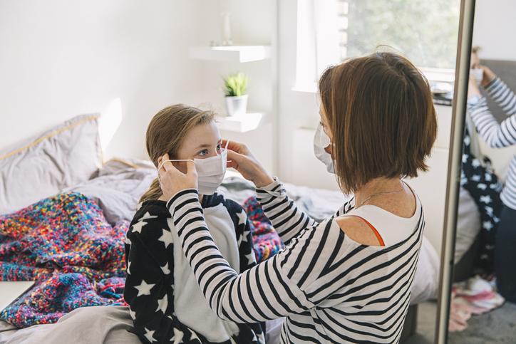 daughter and mother putting on face coverings