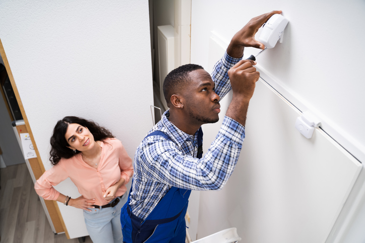 man installing carbon monoxide detector 