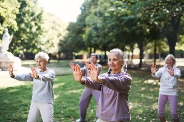 Group of senior women doing exercise in outdoor park