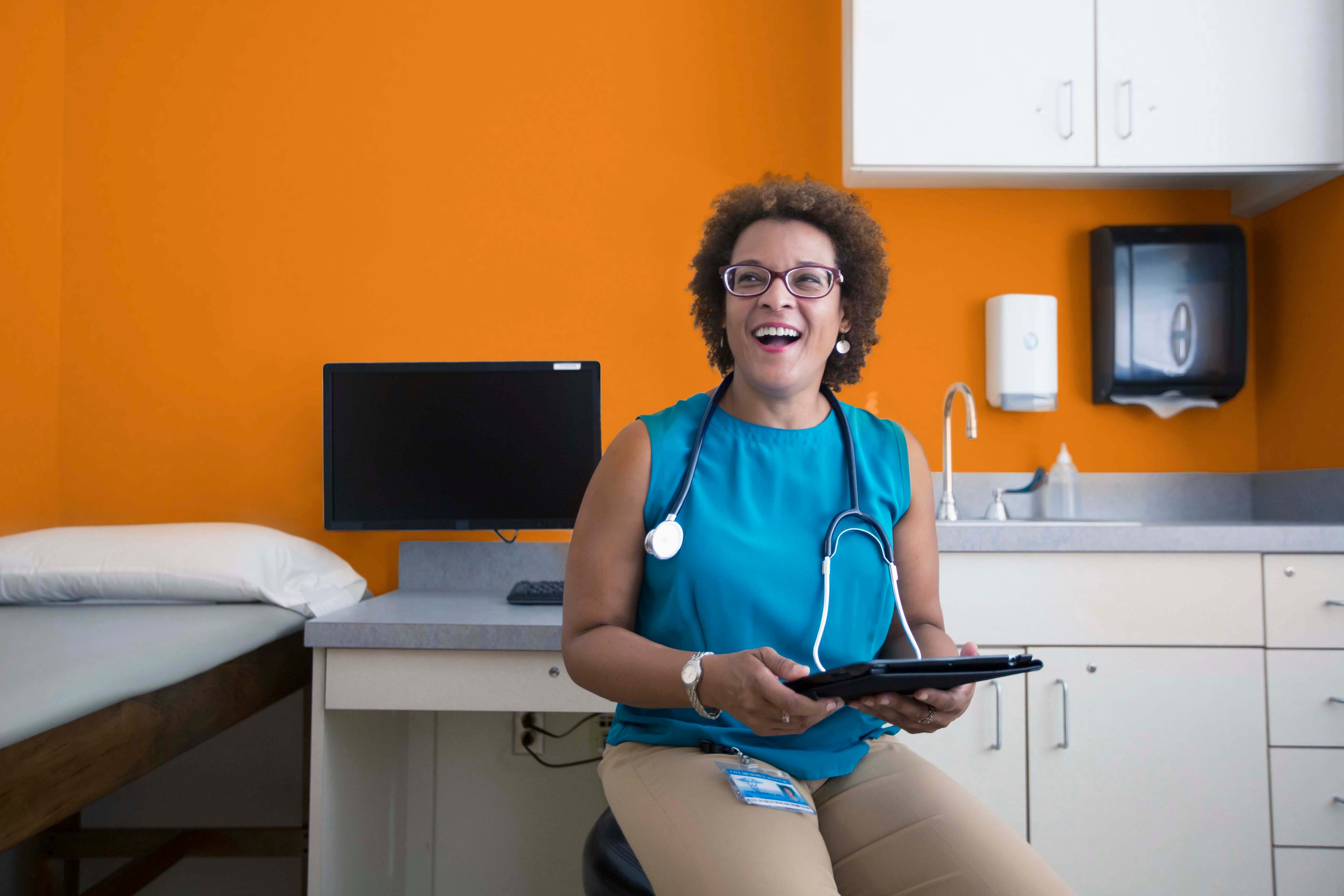 smiling female doctor holding an ipad
