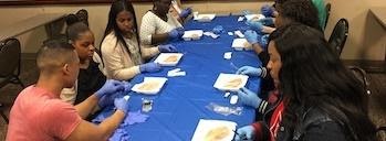 people around a table with medical supplies