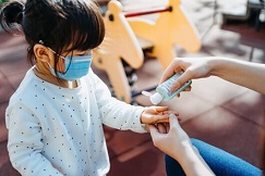 child getting hand sanitizer