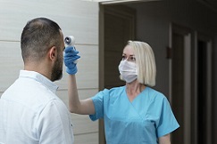 nurse taking patient's temperature