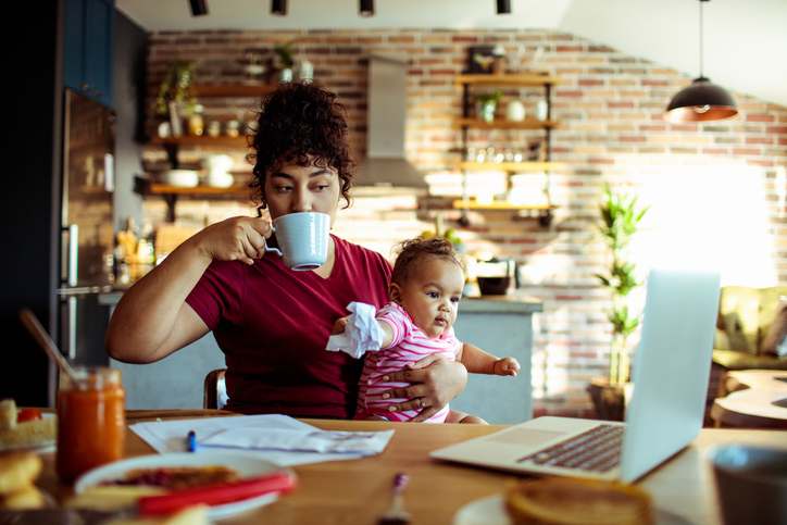Mom drinking coffee while holding baby