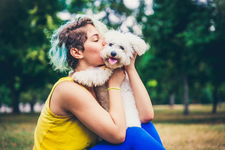 Woman kissing her dog