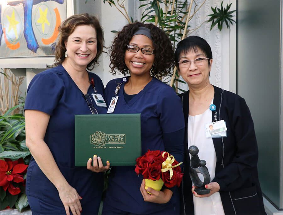 nurses holding awards and flowers