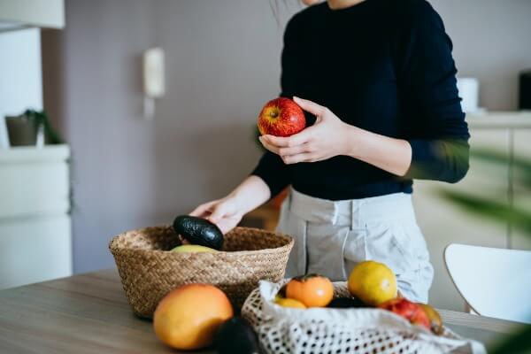 woman grabbing fruit out of a basket