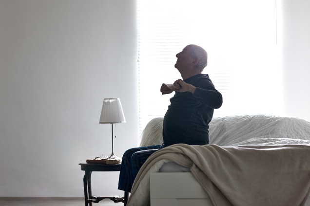 Man stretching, getting up from bed