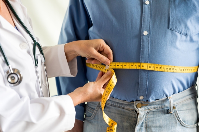 Man getting measured around the waist by a physician
