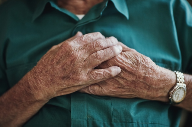 Older person holding hands to heart