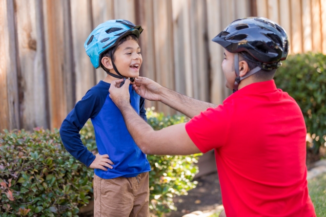 Father putting helmet on his son