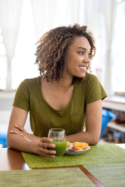 Young woman drinking a green smoothie