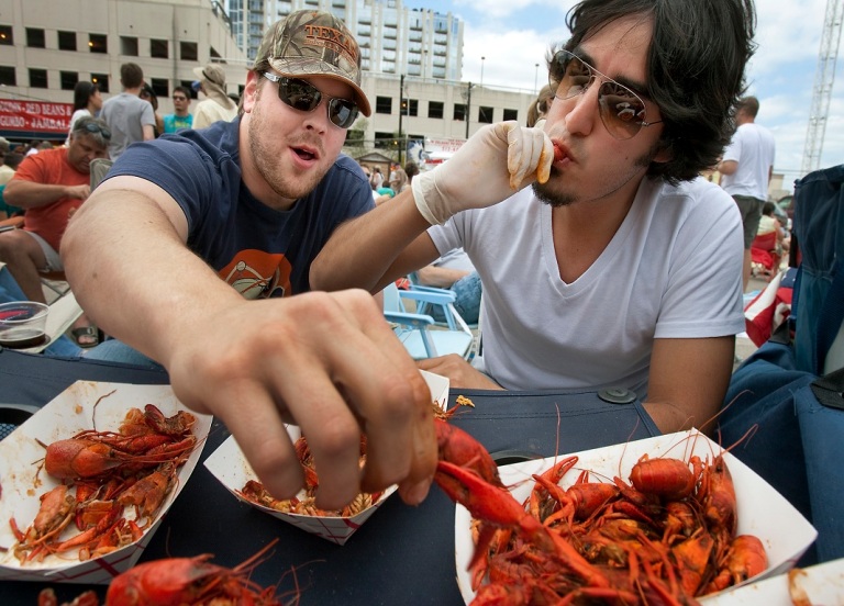 Two Men eating crab legs at Mardi Gras
