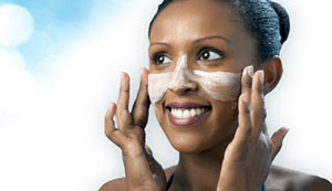 Woman putting facial wash on her face