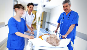 Doctors wheeling in patient with hospital stretcher bed