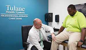 A doctor examining an athletes knee