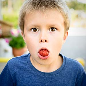 child eating a strawberry